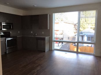 Spacious living area at Vibe Apartments, Seattle, with bright natural light, modern furniture, and large windows.