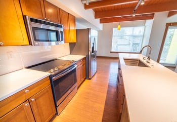 Union Bay Lofts Seattle apartment interior: bright living room with hardwood floors and large windows.