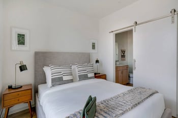 a bedroom with a bed and a bathroom with a shower