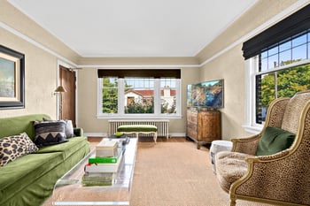 a living room with a green couch and a large window