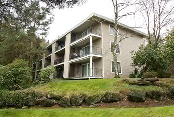 Bright living room at Hill Crest Apartments, Tukwila, WA, with large windows and neutral décor.