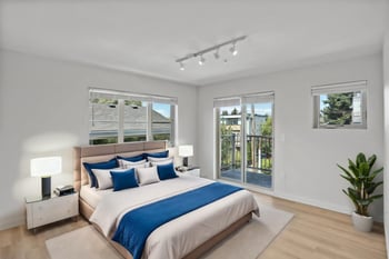 a bedroom with a bed and two windows