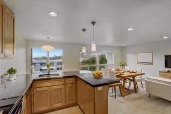 Kitchen and dining area with a counter, chairs, and view of the living room.