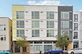 Exterior of Ludwig Apartments, a modern multi-story building with yellow and grey panels and many...