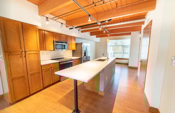 Union Bay Lofts Seattle rental: bright living area with large window and modern kitchen.