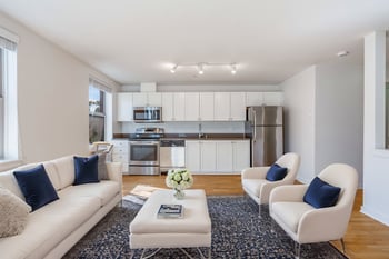Bright living room at Gilbert House Apartments, Seattle, WA; open layout, wood floors, large windows.