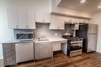Spacious living area with hardwood floors and large windows at Lillehammer Apartments, Seattle, WA