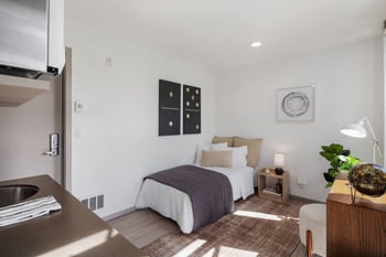 a bedroom with a bed and a desk in a small room