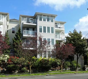 Apartment building with trees in front of it.
