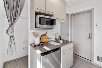 a small kitchen with stainless steel appliances and a microwave