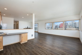 A large, empty room with wooden floors and white walls.