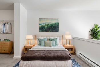 Bright living room in ADA-friendly unit at Gilbert House Apartments, Seattle, WA; large windows, hardwood floors.