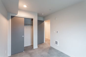 Robins Nest apartment in Seattle: bright living room with modern kitchenette, oak flooring, and balcony.