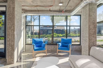 a living room with blue couches and large windows