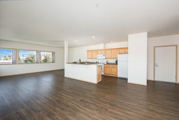 A kitchen with white cabinets and a wooden floor.