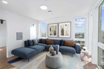 a living room with a blue couch and a round coffee table