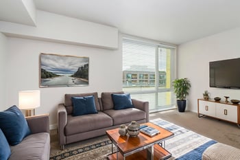 Bright living room at Ludwig Apartments, Seattle, WA; open-concept layout with large windows for rent.