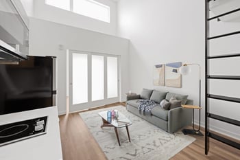A modern living room with a grey couch and a coffee table.