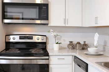 a kitchen with white cabinets and stainless steel appliances