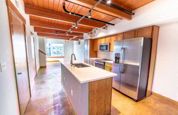 Union Bay Lofts Seattle studio apartment with bright living area, large windows, and modern kitchenette.