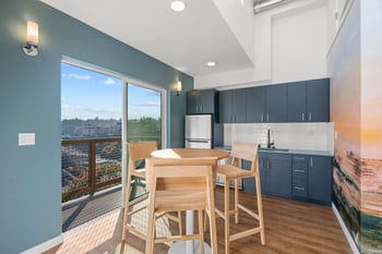 a dining room with a table and chairs and a balcony
