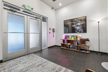 Secure building entryway at Ludwig Apartments featuring dark tile flooring, double exit doors, and music decor.