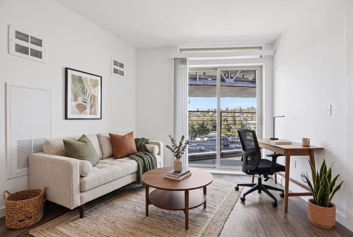 Spacious living room with a comfortable sofa, wood desk, and sliding glass door with a view at Od...