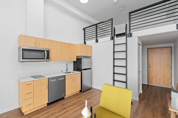 a small apartment with a kitchen and a loft bed