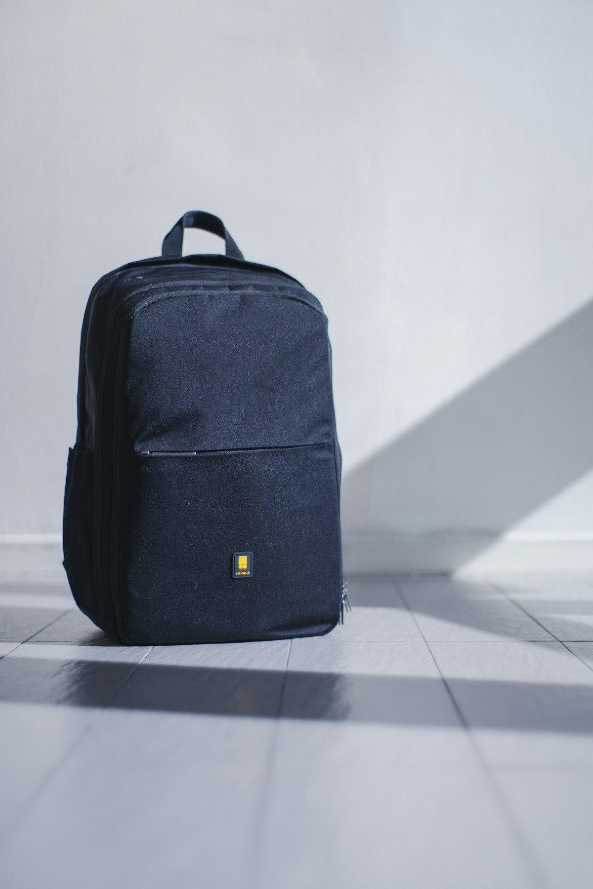 Morral negro con detalle amarillo sobre piso blanco