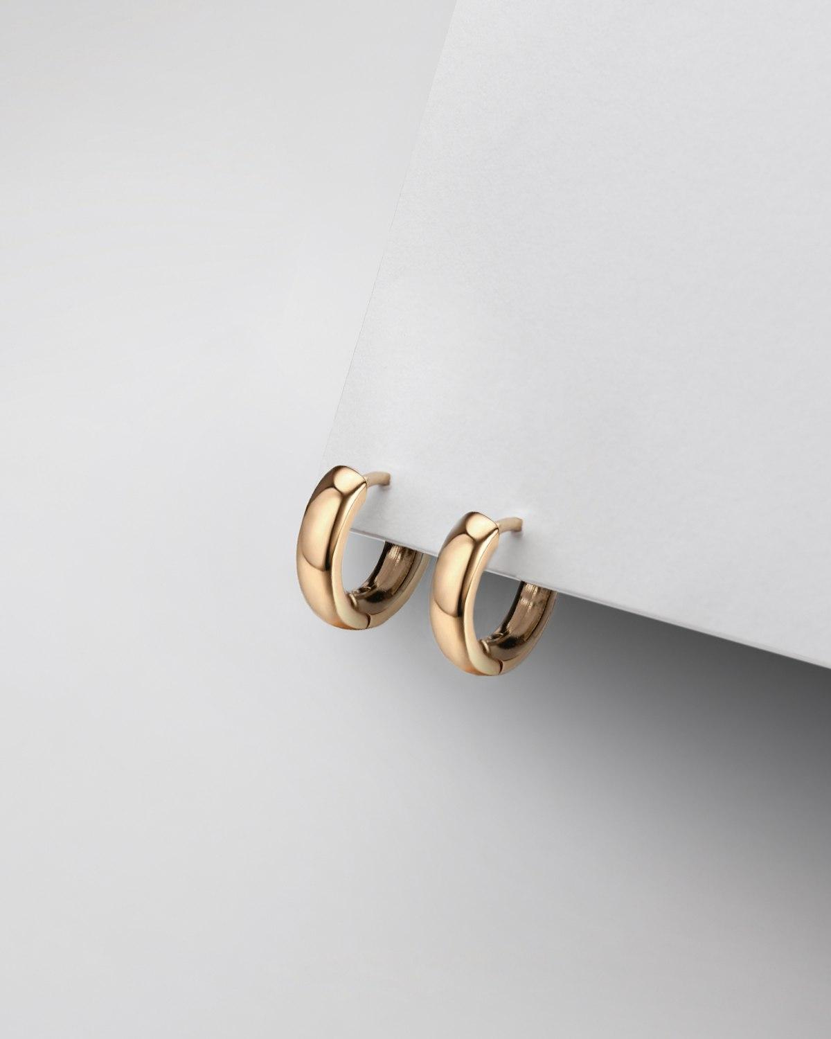 Argollas grandes en oro sobre fondo gris