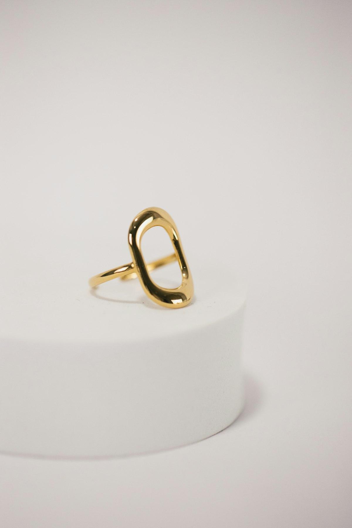 Anillo de diseño abierto en oro sobre pedestal blanco