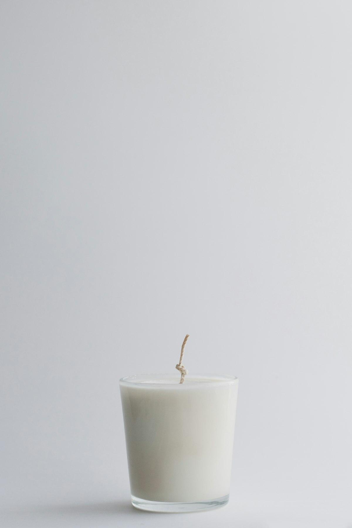 Vela blanca en frasco de vidrio