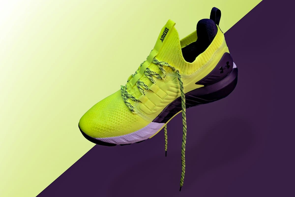 Tenis de running amarillo neón flotando sobre fondo morado