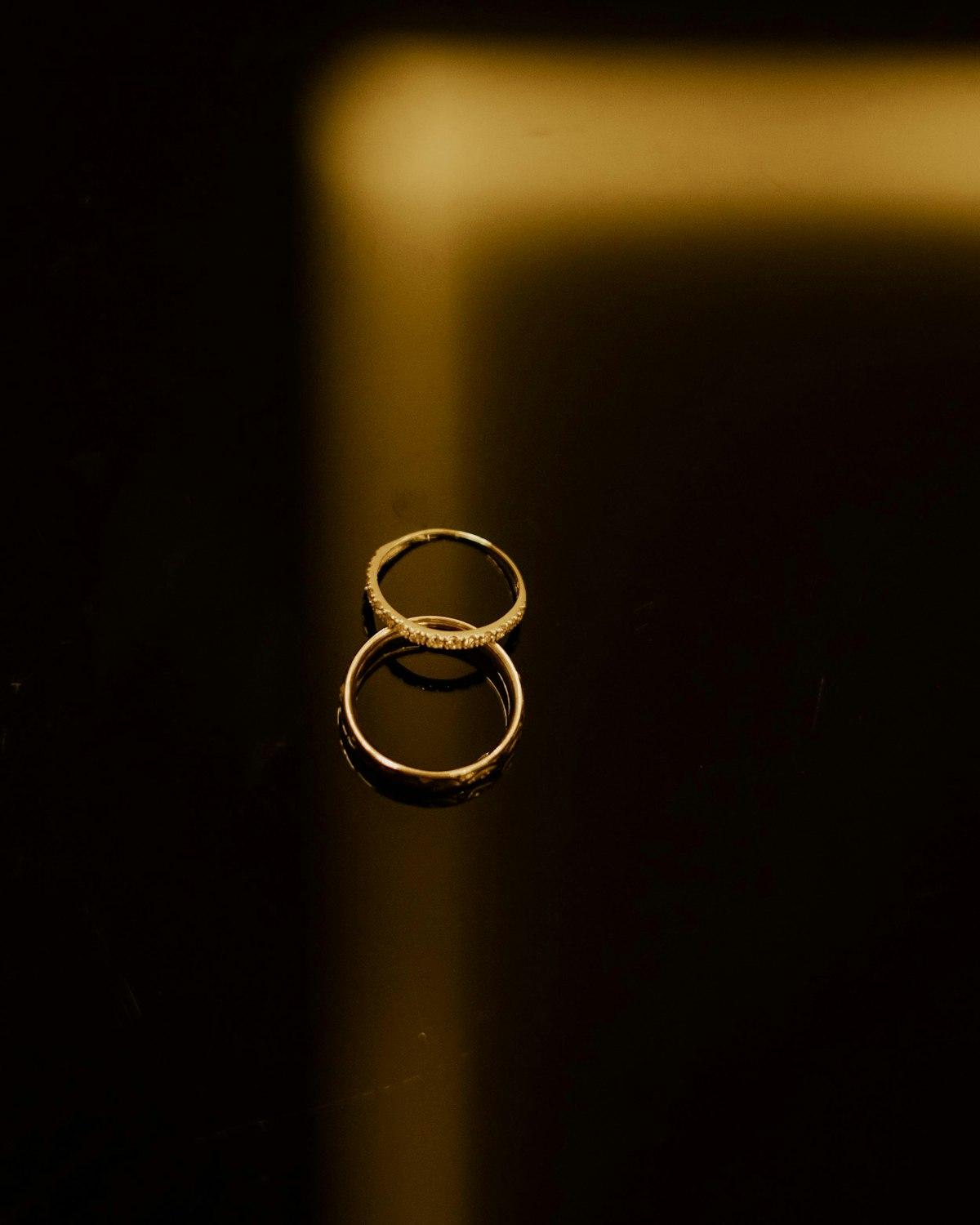 Dos anillos en oro apilados sobre superficie oscura