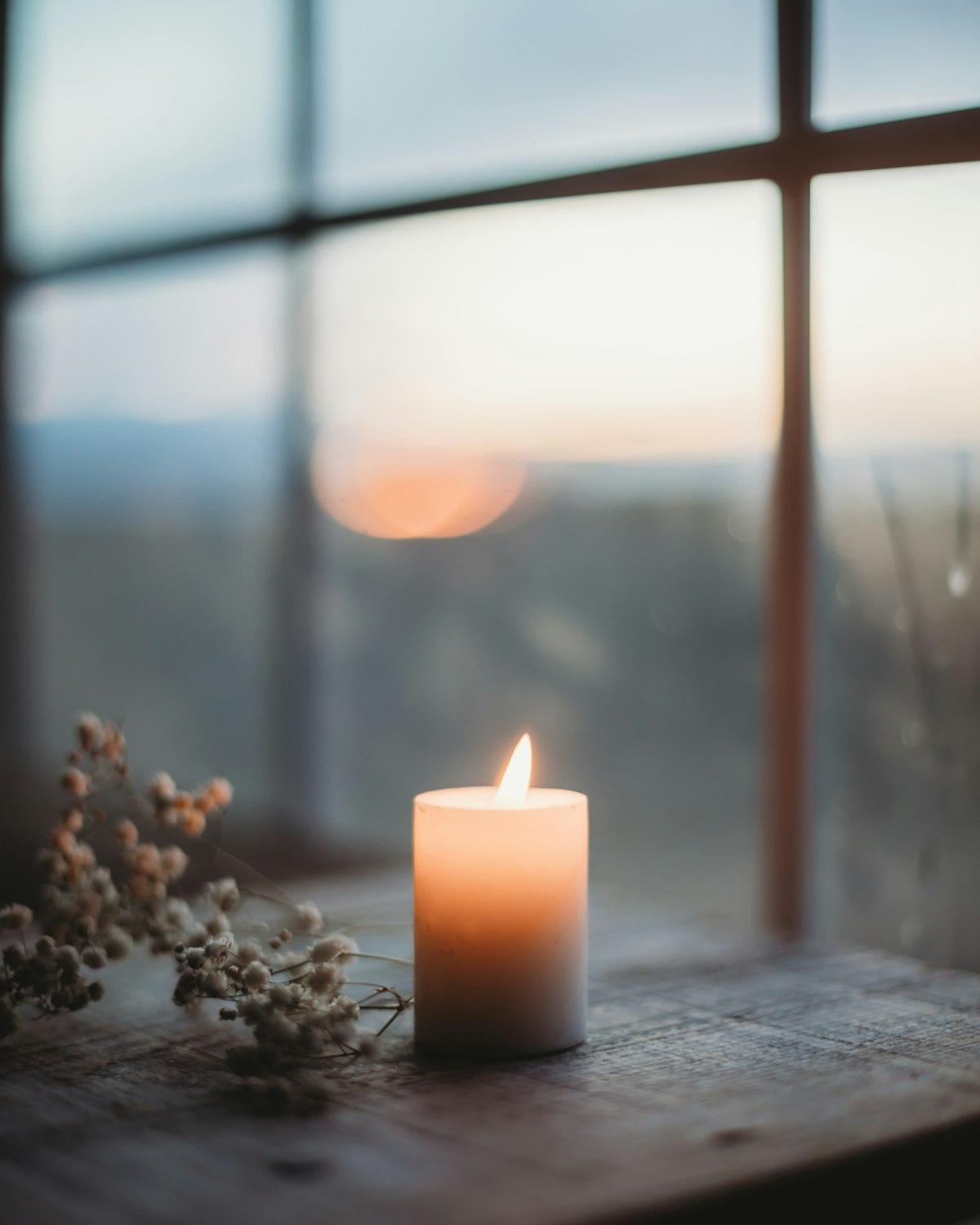 Vela encendida sobre mesa de madera