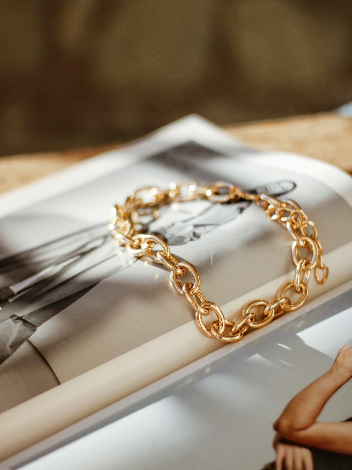Pulsera de cadena en oro sobre una revista