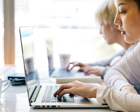 Students working in a modern workspace as the return on investment of college tuition is compared with on-the-job training and trade schools in 2026