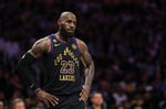 LeBron James in Los Angeles Lakers jersey during NBA playoff game with uncertain expression about retirement decision