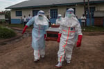 Medical staff in PPE carry a patient at an Ebola treatment centre in DRC's Ituri province, 2026