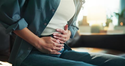Person suffering from stomach pain caused by cyclosporiasis parasite infection