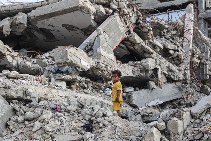 Palestinian child stands amid rubble destroyed building near al-Shati refugee camp western Gaza City July 1 2026