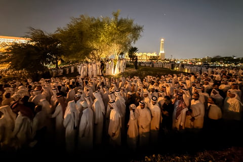 Mourners in traditional Qatari dress attend funeral prayers for Sheikh Hamad bin Khalifa Al Thani at mosque in Doha