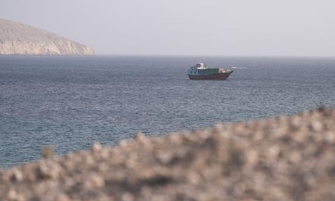 A vessel navigates the Strait of Hormuz as large commercial tanker traffic has nearly stopped amid US-Iran conflict in 2026