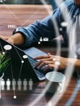 Person using laptop representing Visa payment network's AI-driven workforce reduction