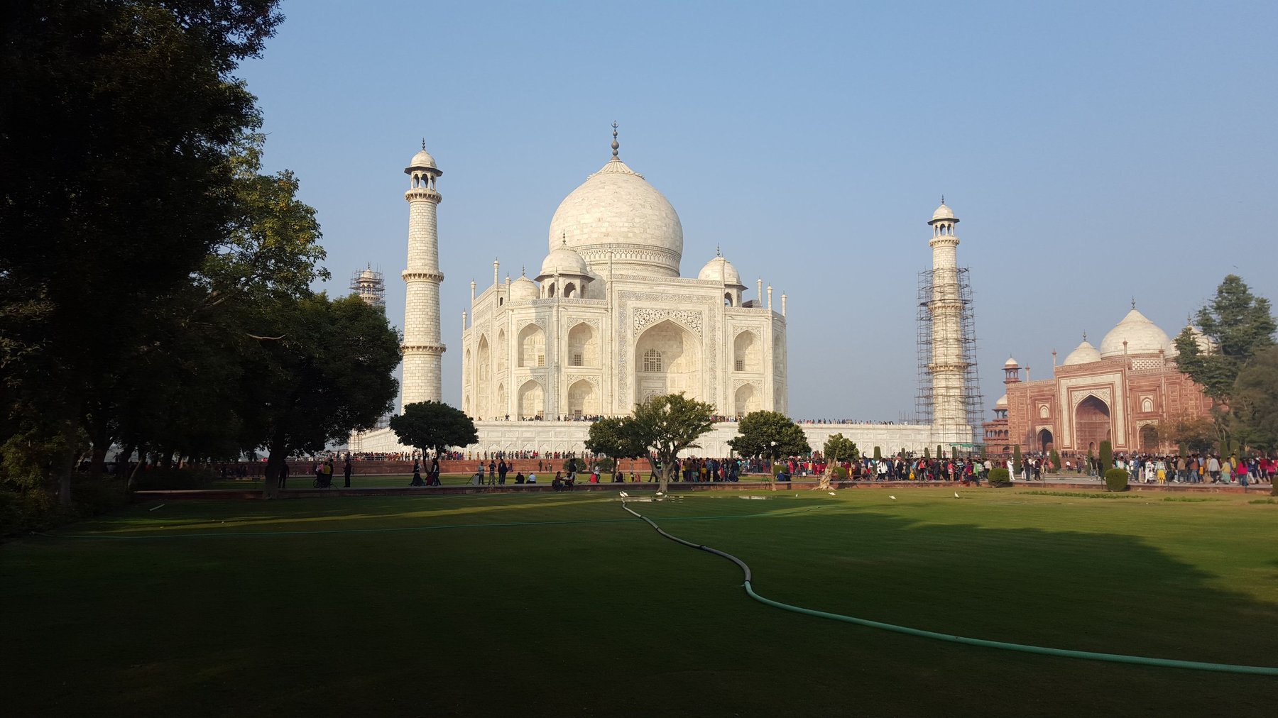 The Taj Mahal from afar, showing a perfect lawn surrounding the mausoleum.
