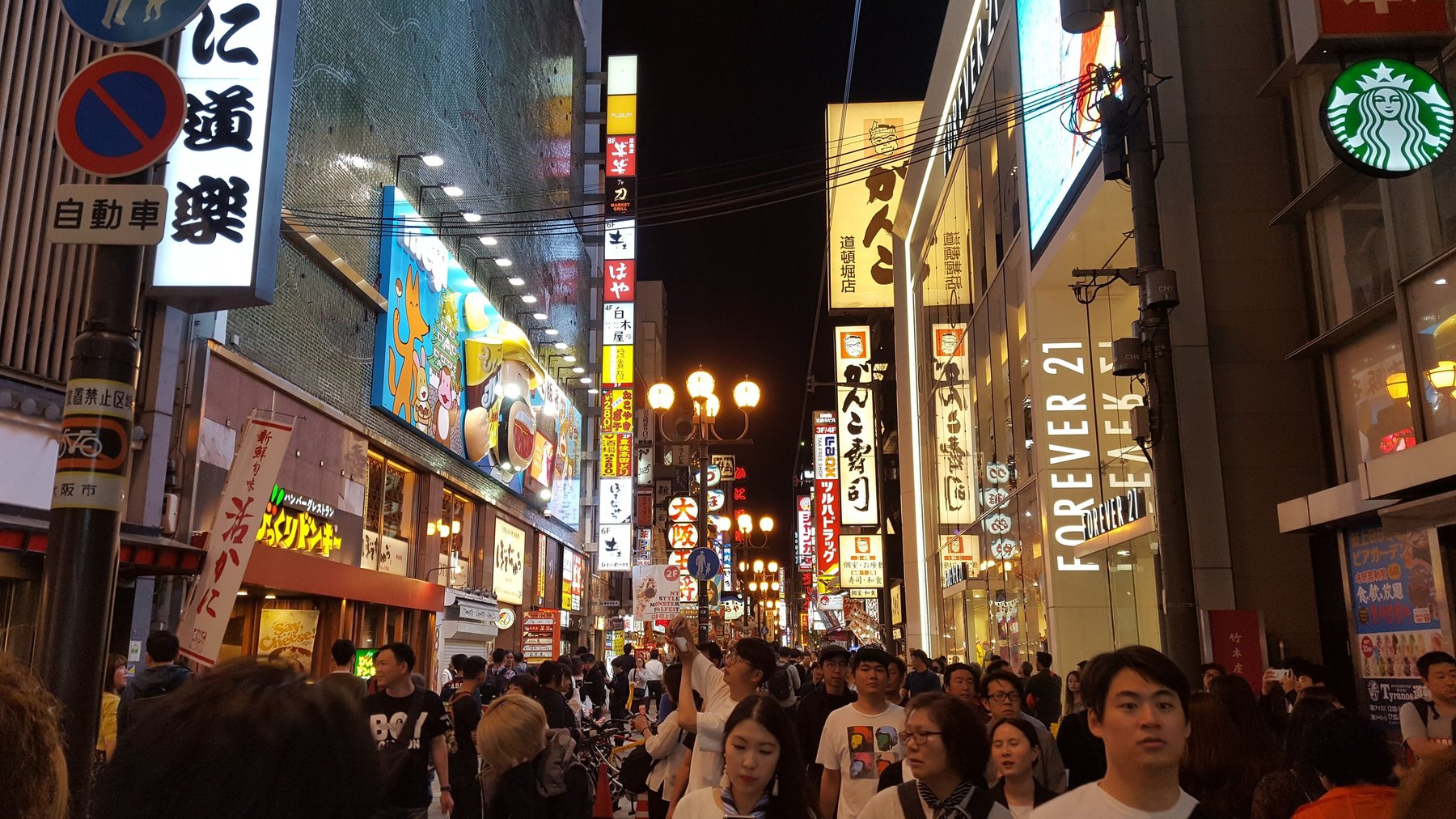 A very crowded, colourful shopping street.