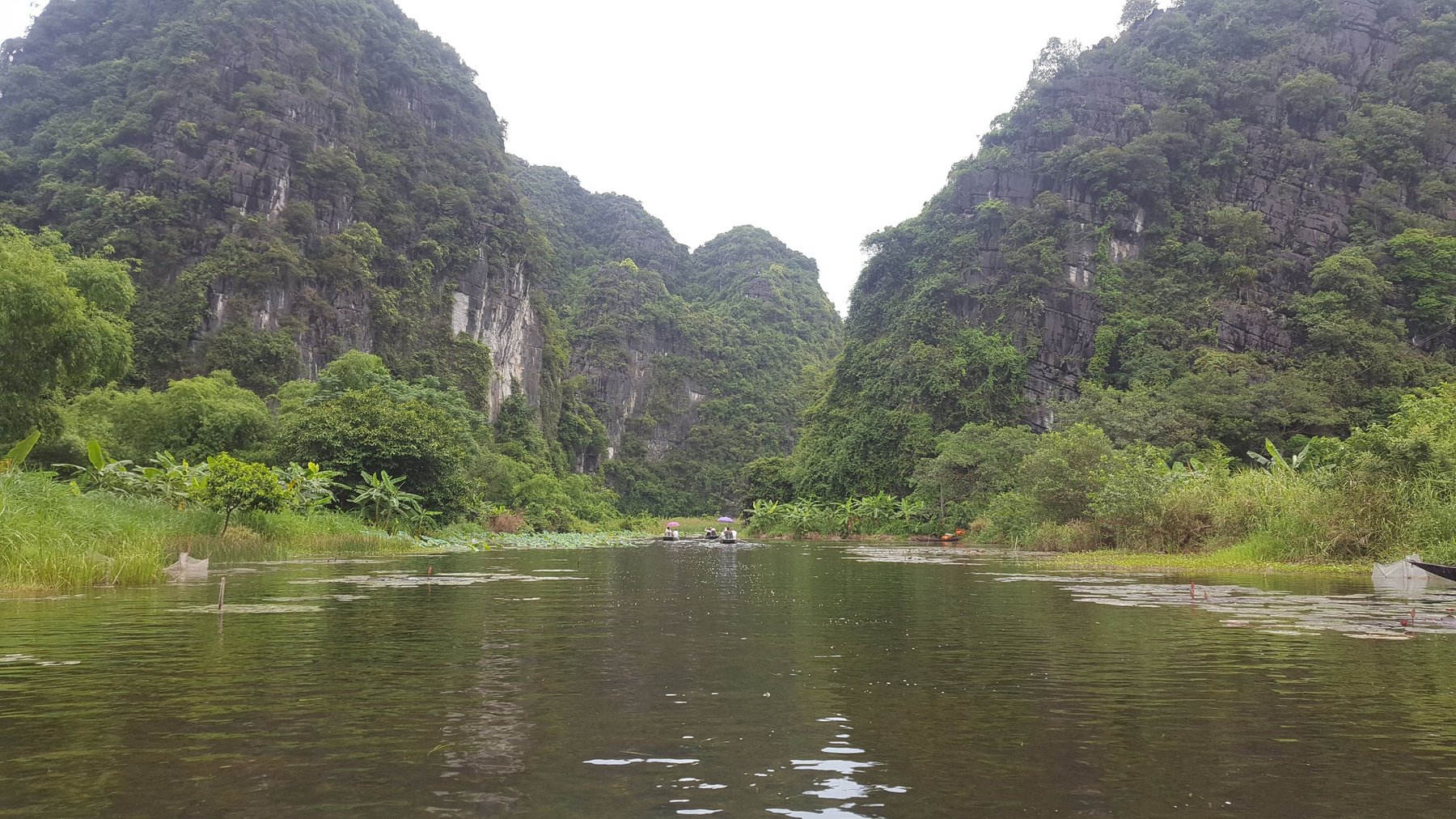 Rocky limestone mountains surround a river bend.