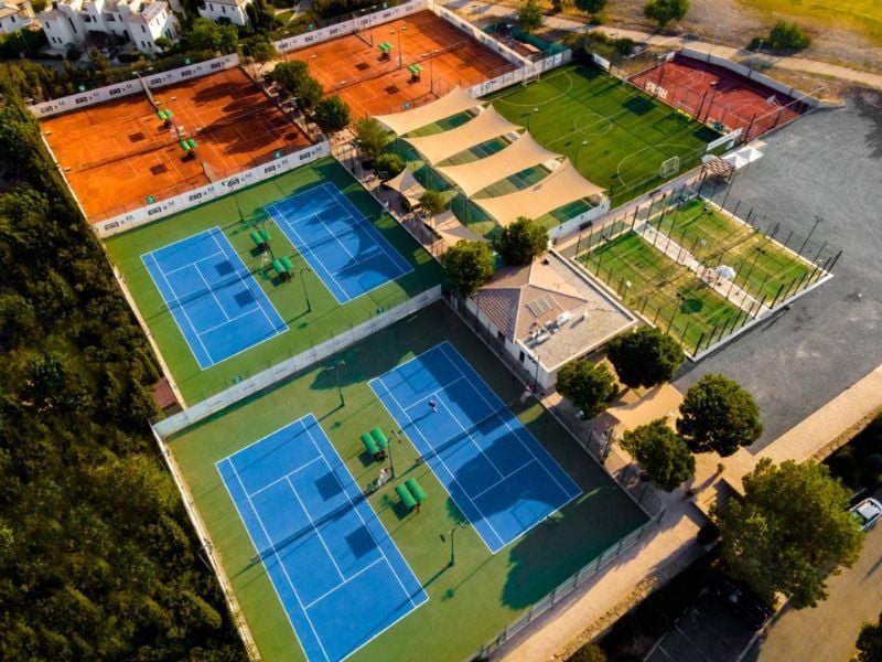 Aerial view of Aphrodite Hills Tennis Academy showing multiple tennis courts and sports facilities.