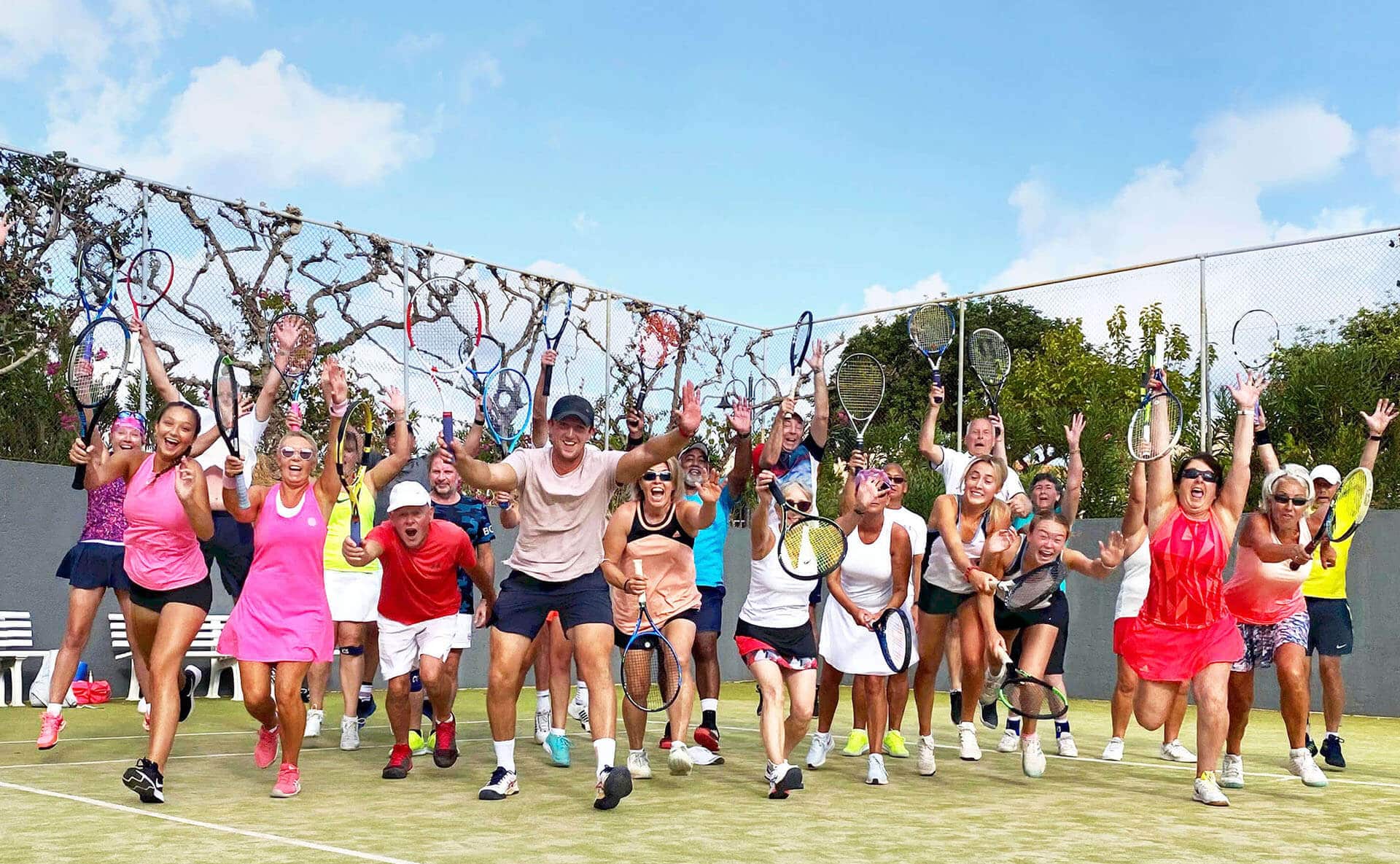 Active-Away-2023-Calendar-Launch Group of tennis players joyfully celebrating on a court holding racquets high, marking the Active Away 2023 calendar launch.