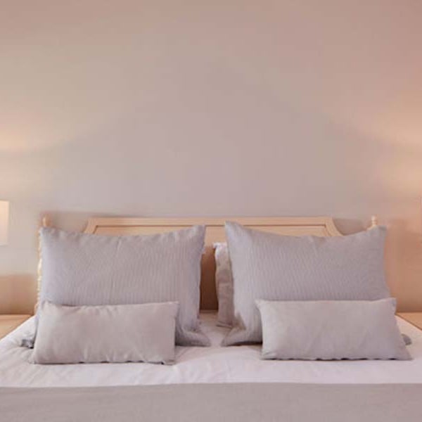 Deluxe double room at Aphrodite Hills with a king-sized bed, plush pillows, and bedside tables with lamps.